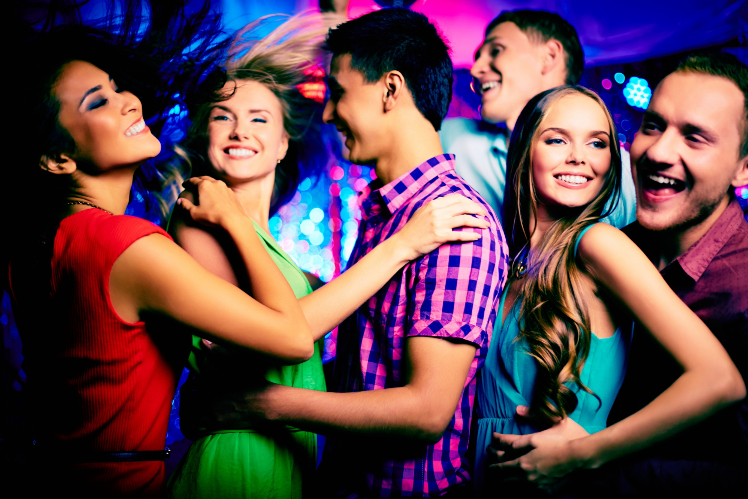 Young adults dancing closely on a vibrant nightclub dance